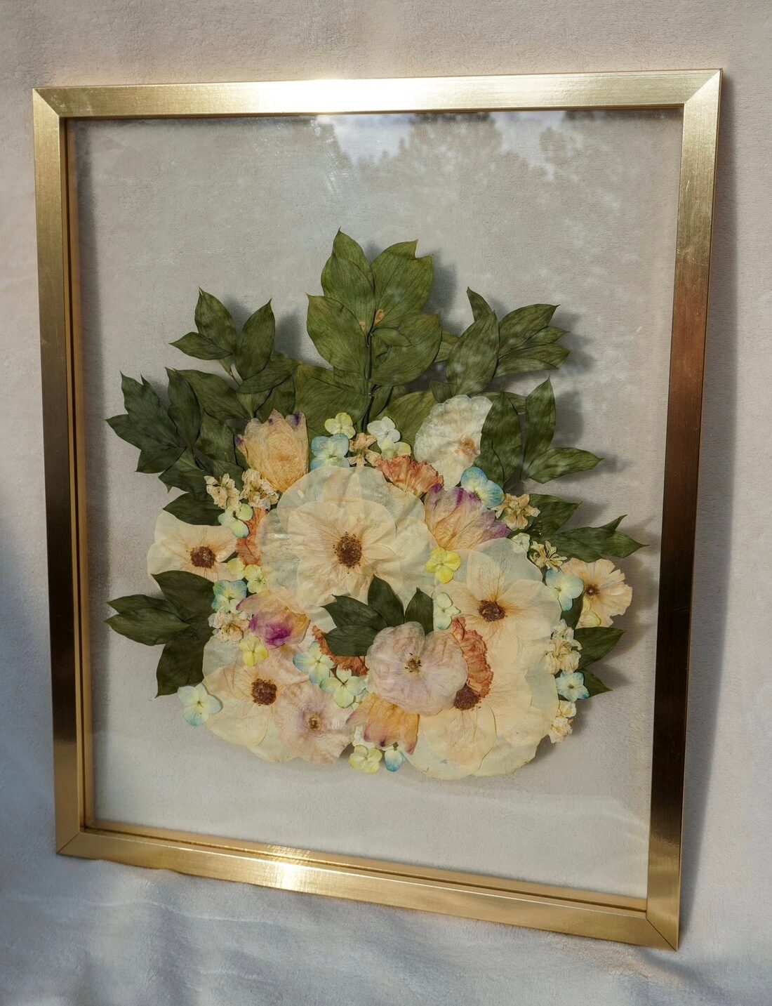 A wedding bouquet pressed by hand and framed as a keepsake